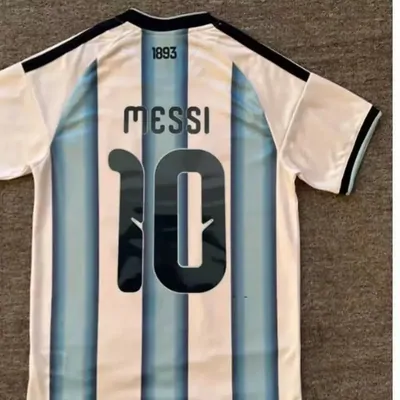 The back of a pale blue and white striped football shirt showing a player name above a large number 10.