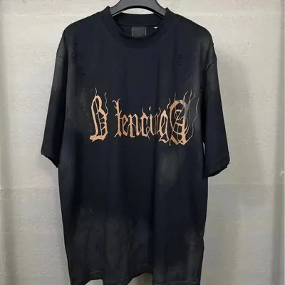 A washed black short-sleeve tee with orange gothic lettering across the chest, on a hanger.